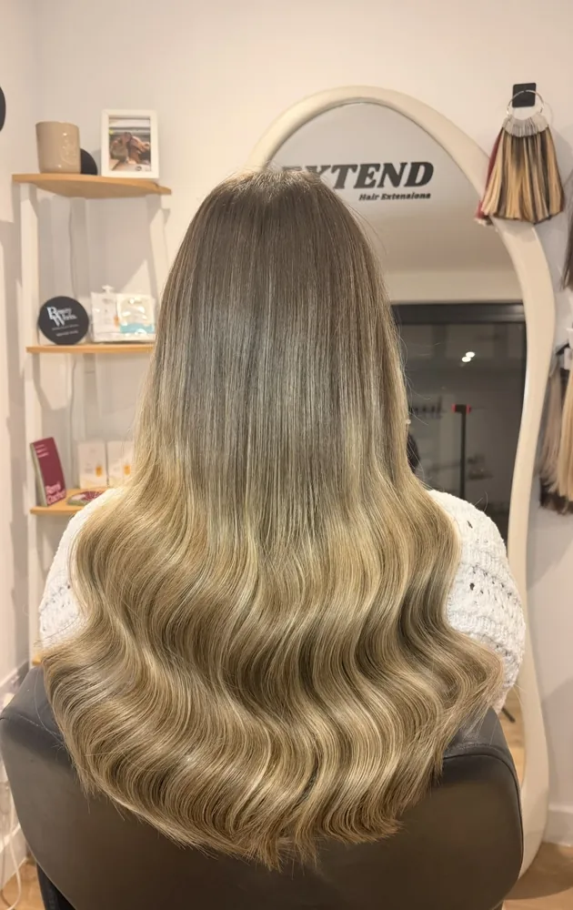 After: long ash-blonde waves with extensions