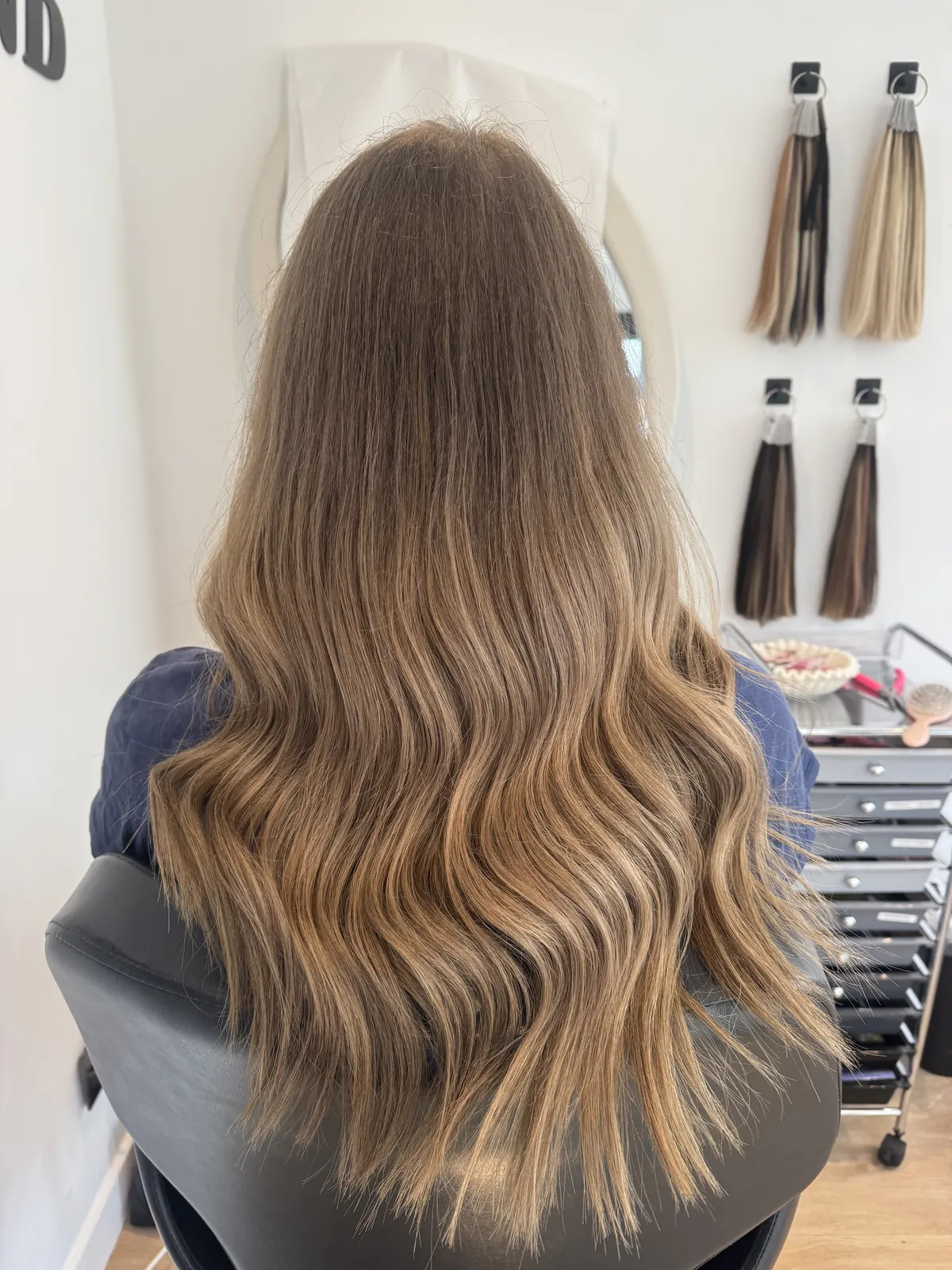 Long, glossy caramel-brown waves after an extensions fitting